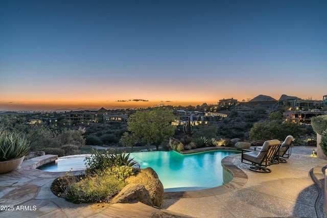 pool at dusk featuring a patio area