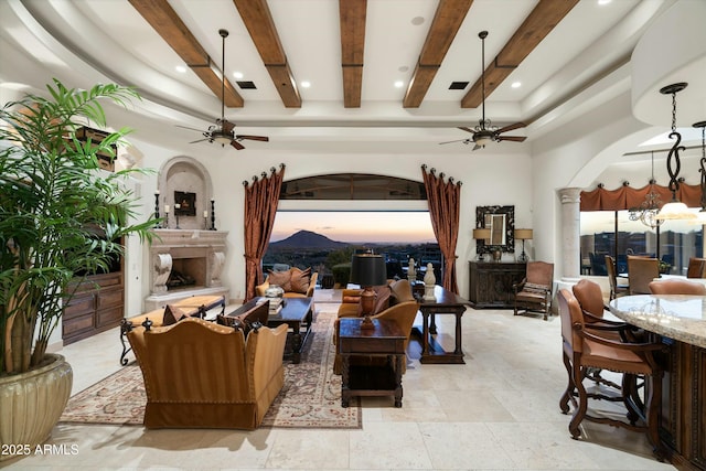 living room featuring ceiling fan with notable chandelier and beamed ceiling