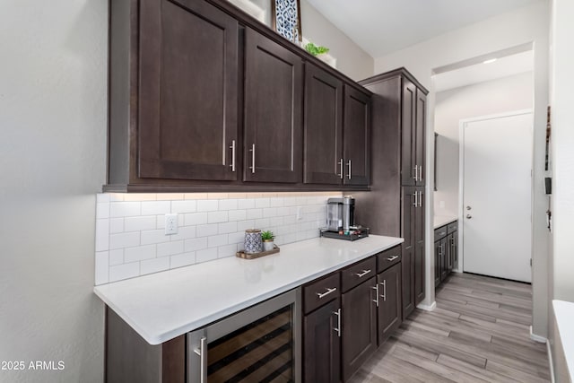 kitchen featuring light hardwood / wood-style floors, beverage cooler, and dark brown cabinetry