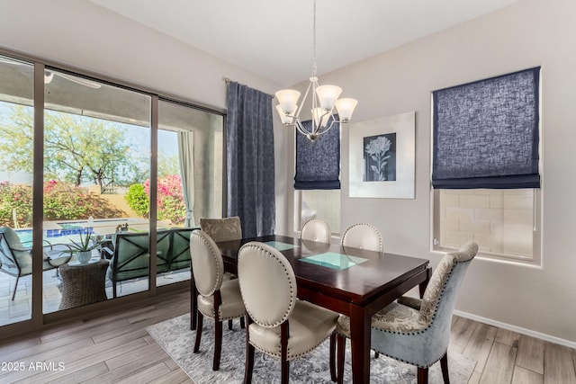 dining room featuring light wood-type flooring and a chandelier