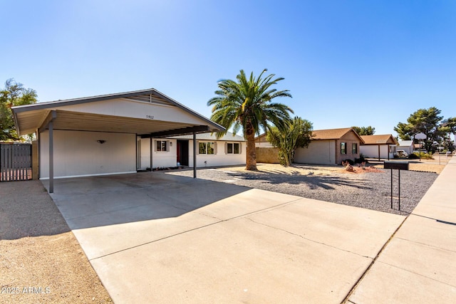 view of front facade featuring a carport, fence, and concrete driveway