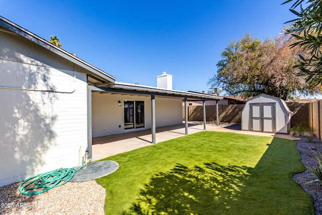 view of yard featuring a shed, a patio area, a fenced backyard, and an outdoor structure