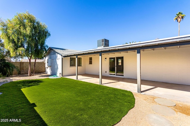 rear view of property featuring central AC, a patio, a lawn, and fence