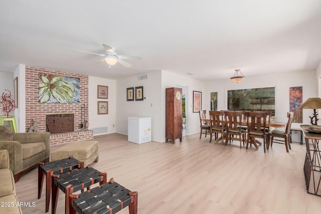 6802 N 26th St, Phoenix, AZ 85016 - living room featuring ceiling fan, light wood finished floors, and a fireplace