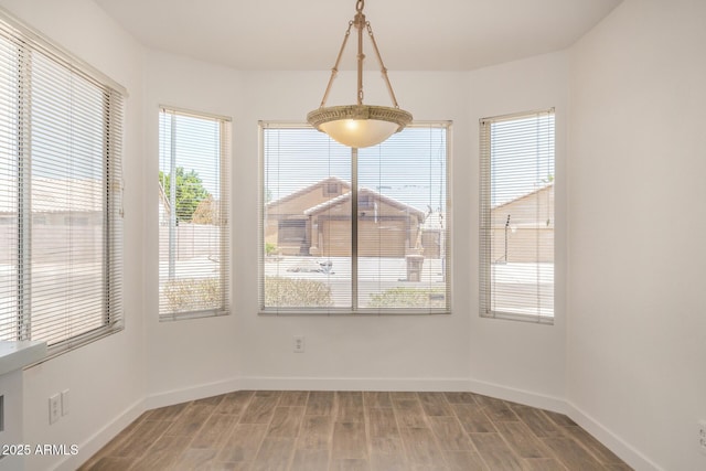 16120 N 86th Ln, Peoria, AZ 85382 - unfurnished dining area with light wood-style floors, healthy amount of natural light, and baseboards