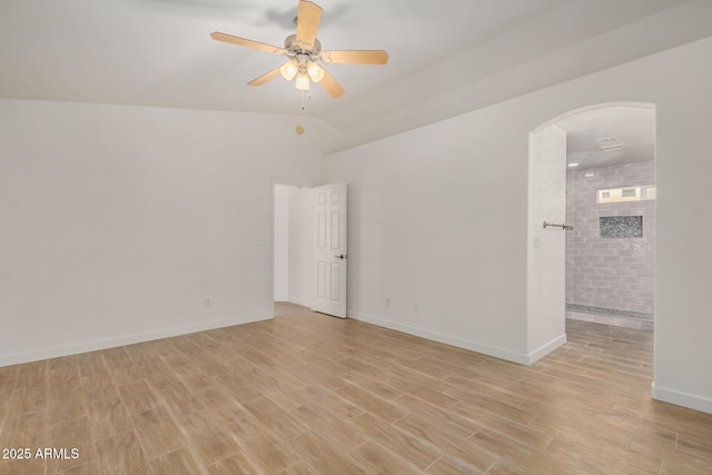 16120 N 86th Ln, Peoria, AZ 85382 - spare room with arched walkways, light wood-style flooring, ceiling fan, baseboards, and vaulted ceiling