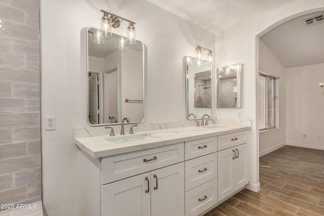 16120 N 86th Ln, Peoria, AZ 85382 - full bath with wood finished floors, double vanity, vaulted ceiling, baseboards, and a shower