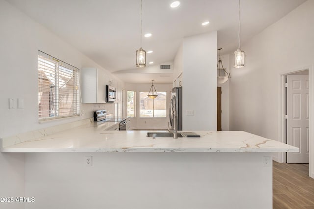 16120 N 86th Ln, Peoria, AZ 85382 - kitchen with stainless steel appliances, a peninsula, white cabinets, light stone counters, and recessed lighting