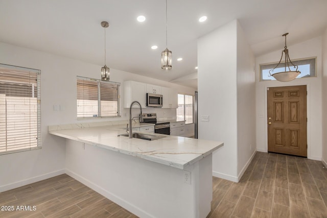 16120 N 86th Ln, Peoria, AZ 85382 - kitchen featuring appliances with stainless steel finishes, a sink, light wood-style floors, baseboards, and vaulted ceiling