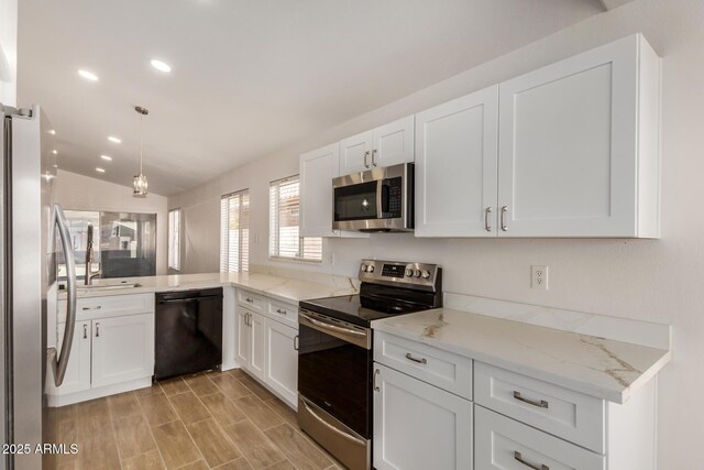 16120 N 86th Ln, Peoria, AZ 85382 - kitchen featuring stainless steel appliances, recessed lighting, lofted ceiling, white cabinets, and light stone counters