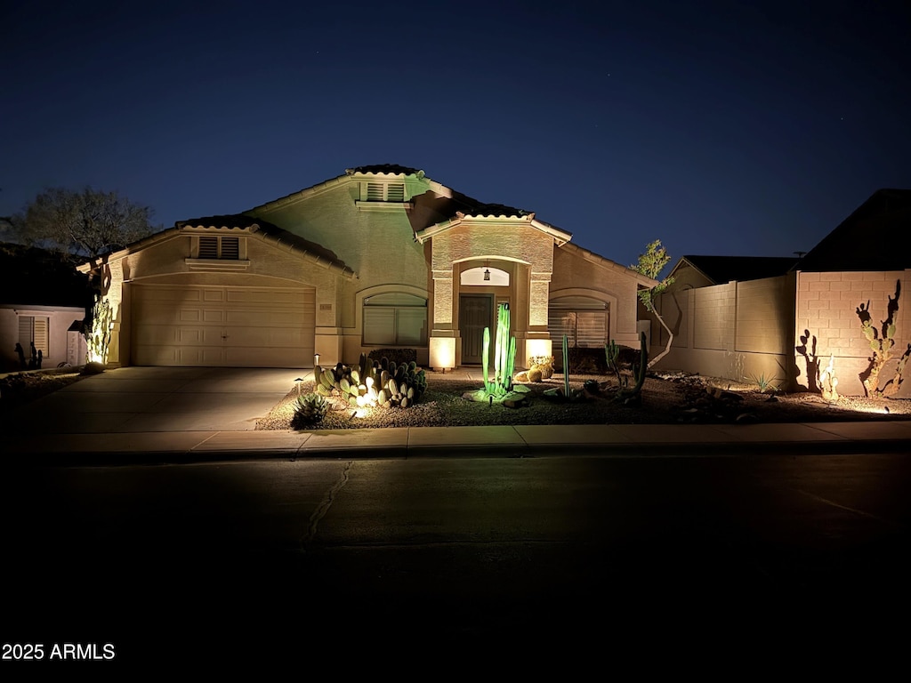 mediterranean / spanish house with concrete driveway, a garage, and fence