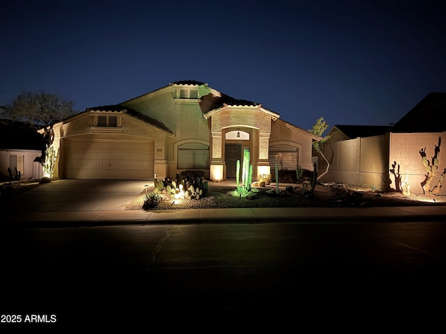 mediterranean / spanish house with concrete driveway, a garage, and fence