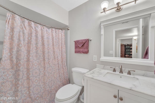 bathroom featuring toilet, vanity, and a shower with curtain