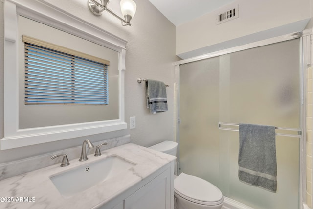 bathroom with toilet, an enclosed shower, and vanity