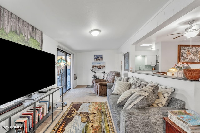 living room with ceiling fan, sink, and light carpet