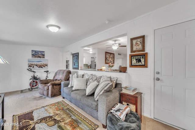 living room with a textured ceiling, ceiling fan, and carpet floors