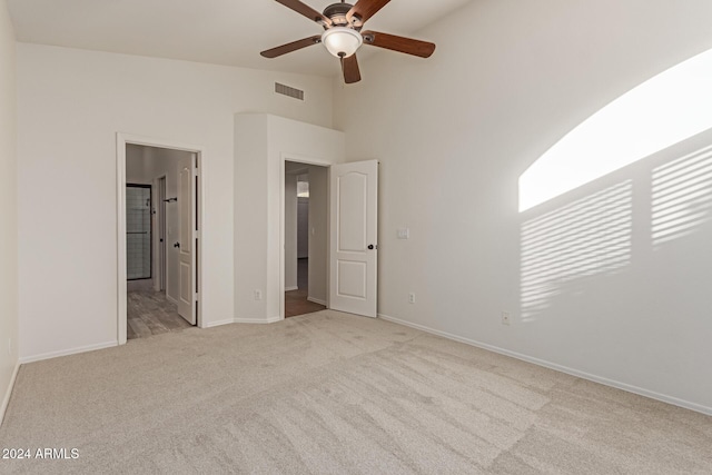 unfurnished bedroom featuring connected bathroom, ceiling fan, and light colored carpet