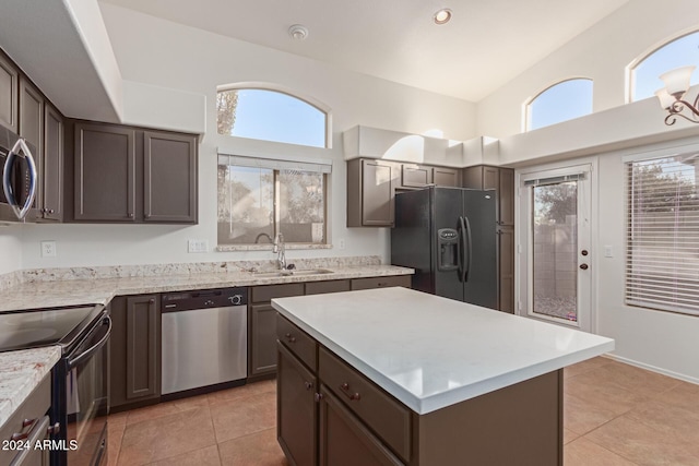 kitchen featuring sink, light tile patterned floors, black appliances, and dark brown cabinets