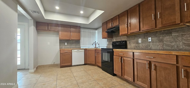 kitchen with light tile patterned flooring, black range with electric stovetop, white dishwasher, tasteful backsplash, and a tray ceiling