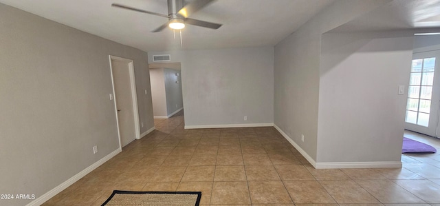 tiled spare room featuring ceiling fan