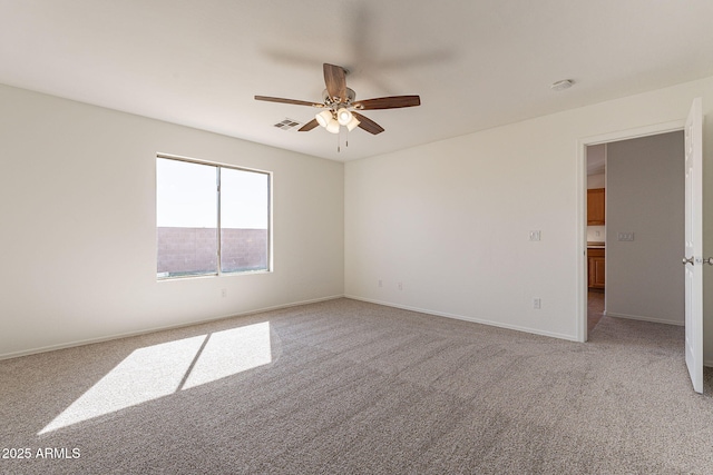 unfurnished room featuring ceiling fan, visible vents, baseboards, and light colored carpet