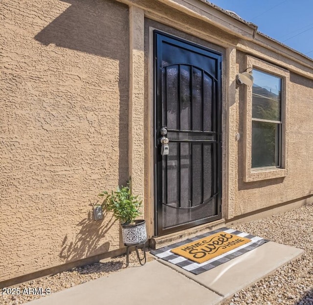 entrance to property featuring stucco siding