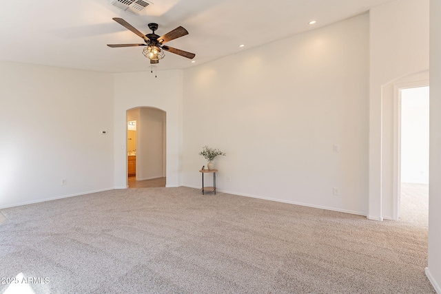 unfurnished room featuring visible vents, arched walkways, a ceiling fan, light colored carpet, and recessed lighting