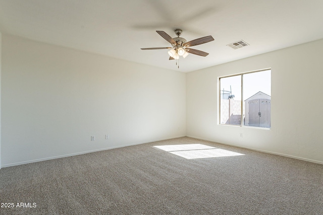 carpeted empty room with visible vents, ceiling fan, and baseboards