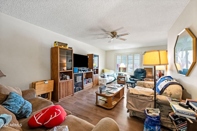 living room featuring a textured ceiling, a ceiling fan, and wood finished floors