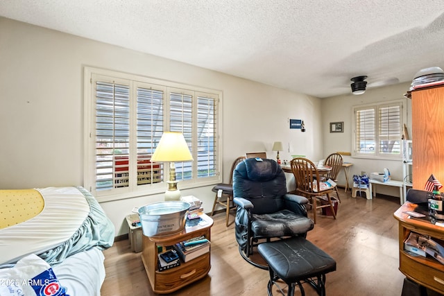 living room with plenty of natural light, a textured ceiling, ceiling fan, and wood finished floors