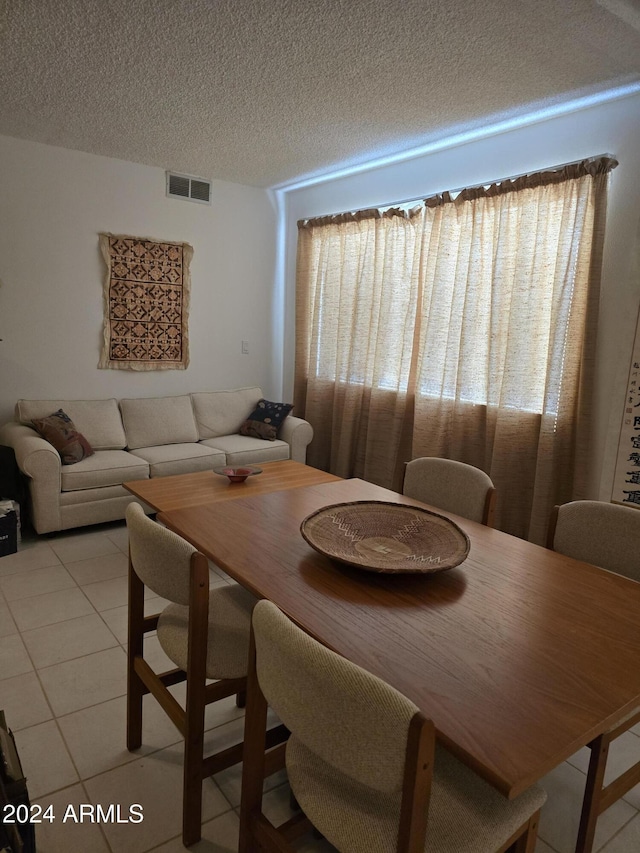 dining area with light tile patterned floors and a textured ceiling