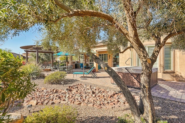 view of playground featuring a patio area, a pergola, and a hot tub