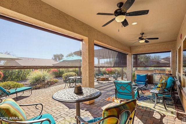 view of patio / terrace with ceiling fan, an outdoor fire pit, an outdoor kitchen, and area for grilling