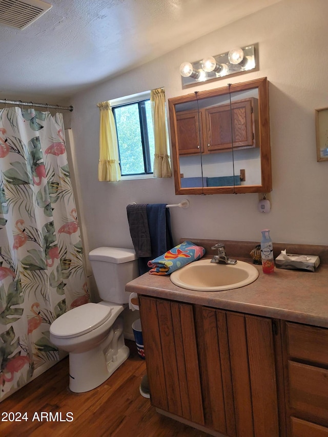 bathroom with a shower with curtain, hardwood / wood-style floors, vanity, and toilet