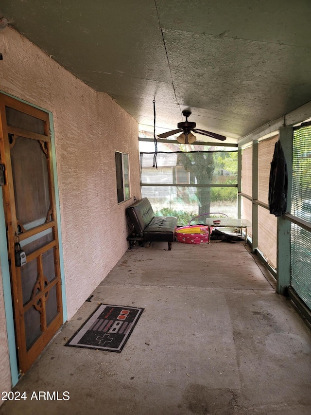 unfurnished sunroom featuring ceiling fan