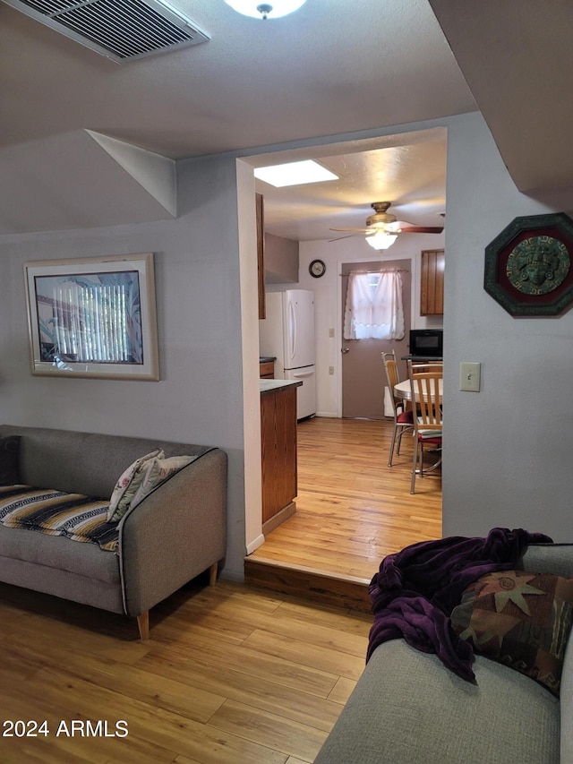 living room with ceiling fan and light wood-type flooring