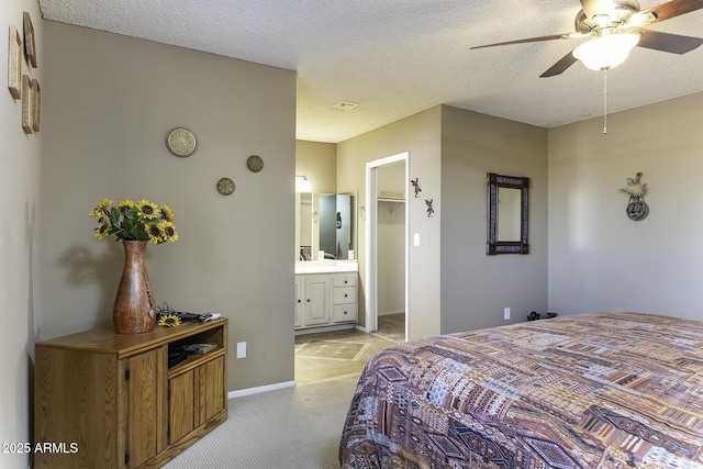 bedroom featuring visible vents, light colored carpet, a spacious closet, and a textured ceiling