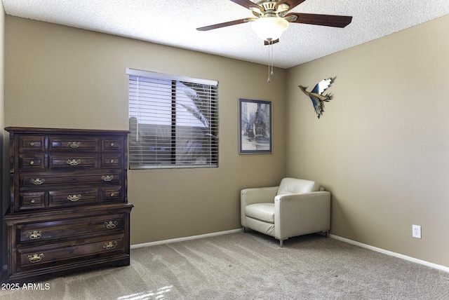 sitting room featuring baseboards, light colored carpet, a textured ceiling, and a ceiling fan