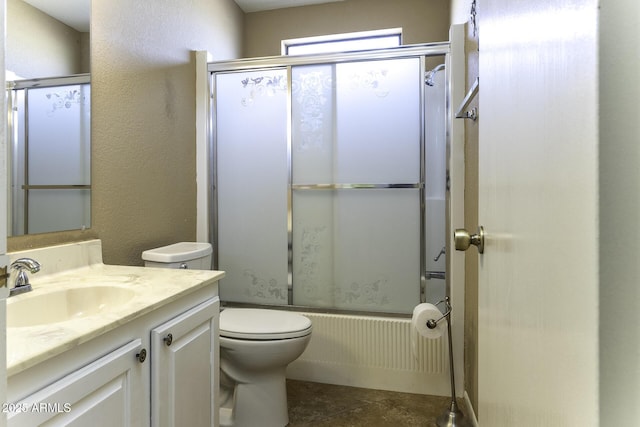 bathroom with vanity, toilet, a textured wall, and enclosed tub / shower combo