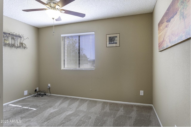 carpeted spare room featuring a textured ceiling, baseboards, and ceiling fan