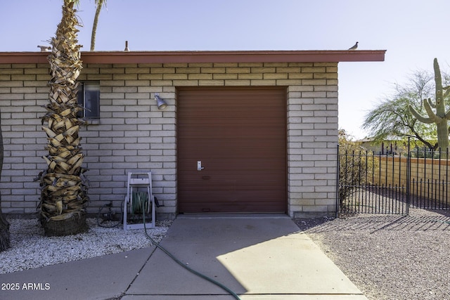 view of outbuilding with fence, a garage, and driveway