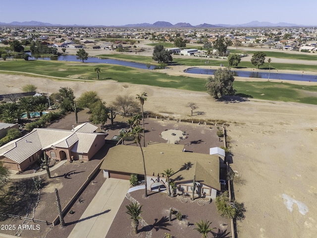 drone / aerial view with a water and mountain view and view of golf course