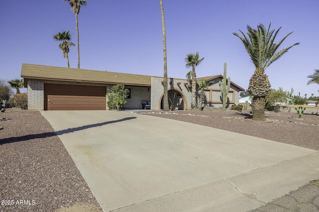 view of front of home with a garage, brick siding, and driveway