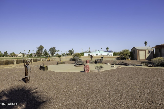 view of yard featuring a patio, a storage shed, an outdoor structure, and fence