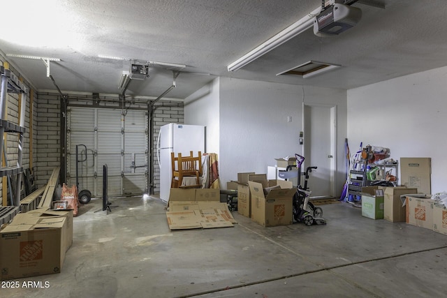 garage featuring freestanding refrigerator and a garage door opener