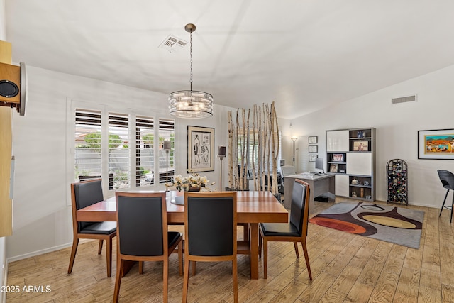 dining area featuring light wood-type flooring, visible vents, and a notable chandelier