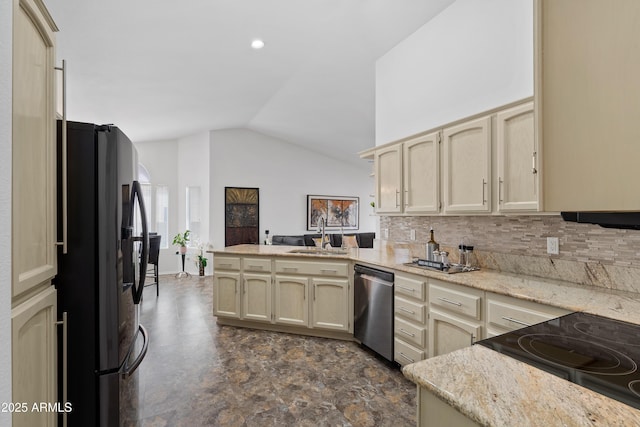kitchen featuring lofted ceiling, dishwasher, a sink, freestanding refrigerator, and a peninsula