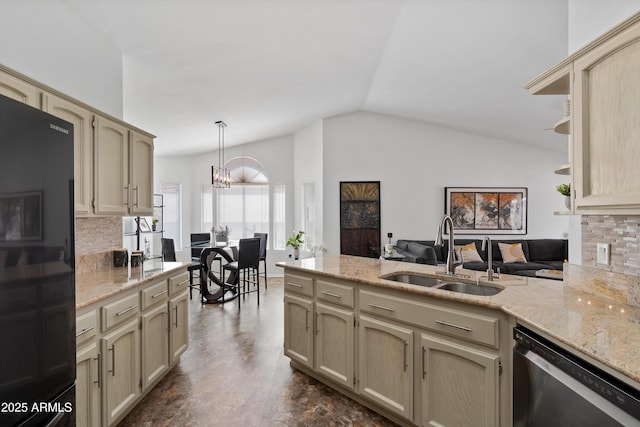 kitchen featuring black refrigerator, lofted ceiling, stainless steel dishwasher, a sink, and a peninsula