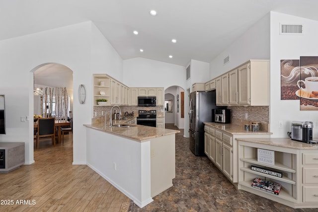 kitchen with open shelves, arched walkways, a sink, and black appliances