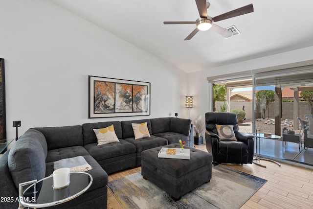 living area featuring vaulted ceiling, wood finished floors, visible vents, and a wealth of natural light